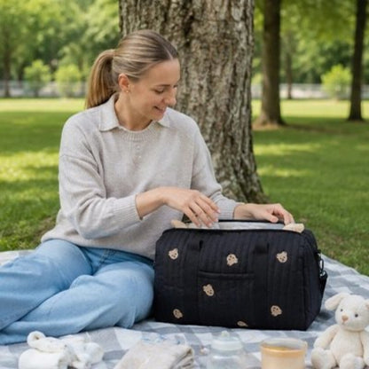 Sac a langer ultra pratique maman est assise sur la pelouse