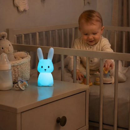 Veilleuse lapin ultra douce bebe est assis dans son berceau